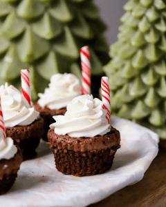 hot cocoa brownie cups with chocolate ganache, whipped cream and a candy cane straw