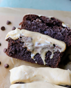 Sliced fudgy chocolate brownie loaf topped with brown butter espresso cream cheese frosting, showing a rich brownie texture and creamy frosting layer.