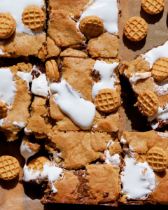 Close-up of fudgy Fluffernutter brownies topped with swirls of marshmallow fluff and dollops of peanut butter cookies cobbled on top.