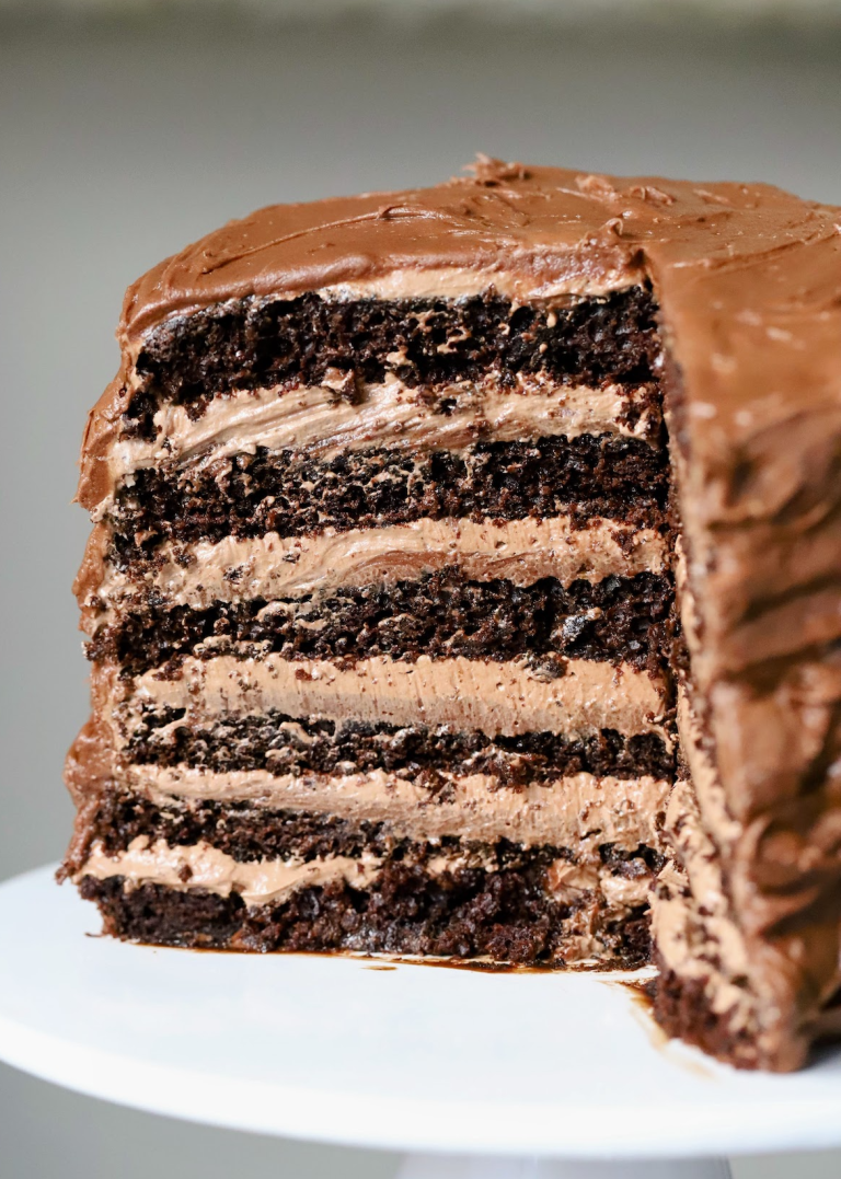 Double Chocolate Cake Sliced exposing 12 layers of rich chocolatey sponge, chocolate cream cheese & swiss meringue buttercream.